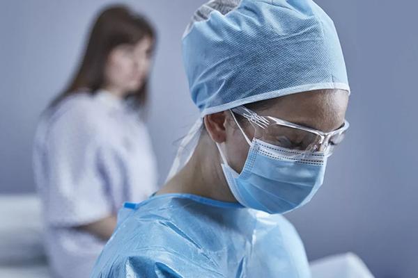 Arts staat voor patiënt die op bed zit in onderzoekskamer