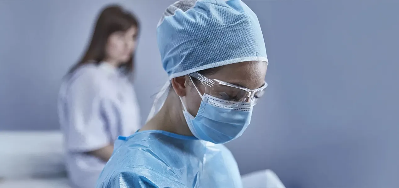 Arts staat voor patiënt die op bed zit in onderzoekskamer