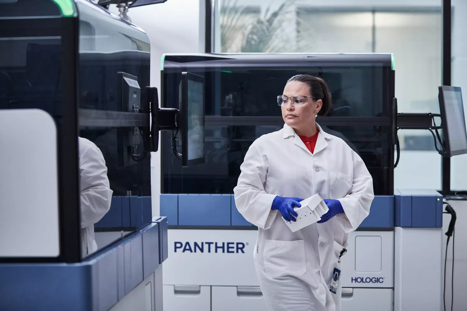 Laborant loopt door Panther systemen in een laboratoriumomgeving