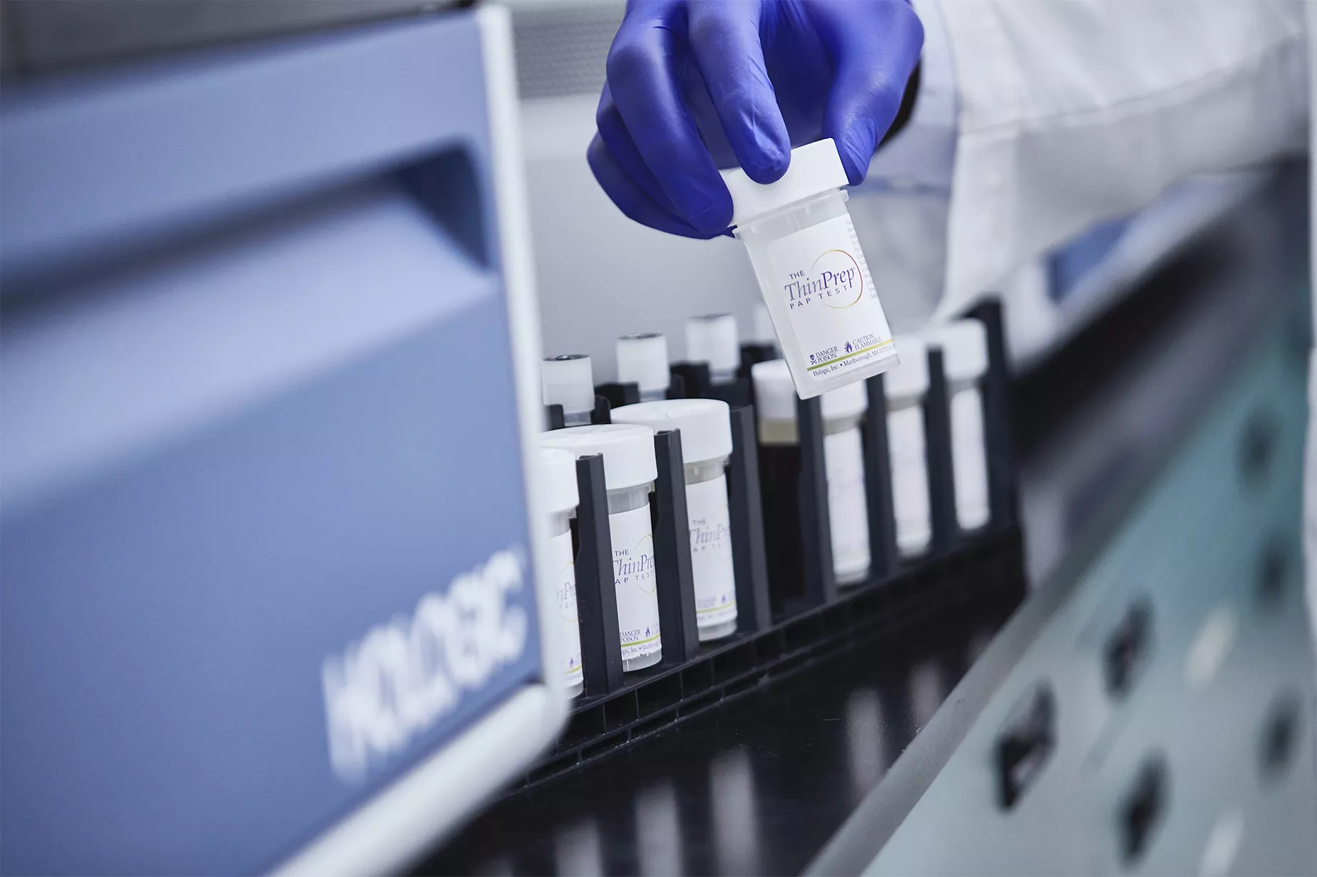 Hand met handschoen houdt flacon vast